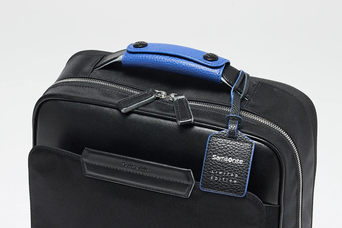 Samsonite（サムソナイト）EPID4（エピッドフォー）2026年の限定モデルの寄り画像。ブランドのシグネチャーカラーのブルーをアクセントしたトップハンドルとタグが特徴。