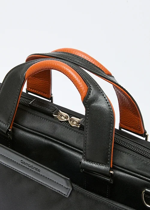 Samsonite（サムソナイト）ビジネス用ブリーフケース、バックパックであるEPID4のハンドル部分の寄り画像。上質なイタリア製レザーを用いたハンドル。オレンジカラーがアクセント。