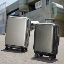 Two luggages standing on concrete